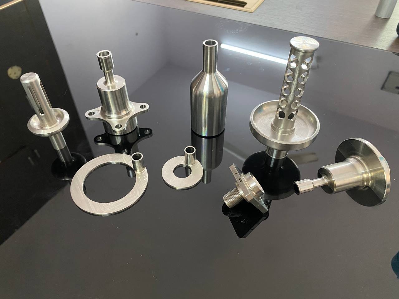 Precision turned components displayed on a black surface