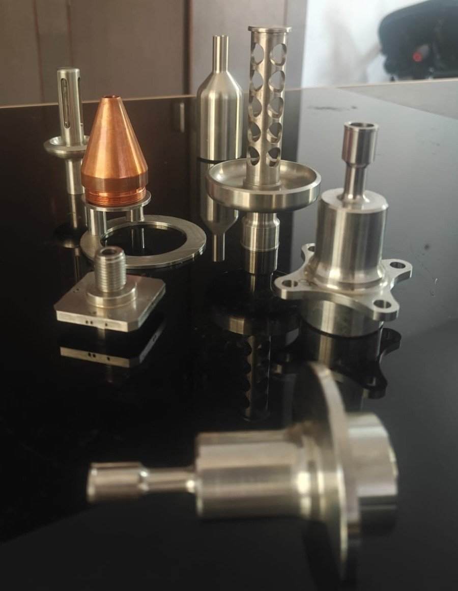 Precision machined metallic components displayed on a black table