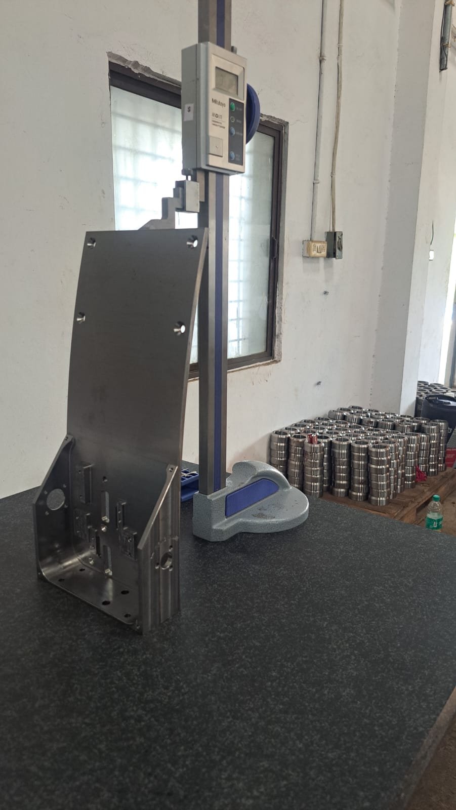 Height gauge measuring a machined component on a granite reference surface